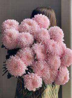 a woman holding a bouquet of pink flowers