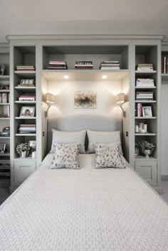 a bedroom with built in bookshelves and a bed that has pillows on it