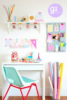 a white desk topped with lots of colorful items next to a shelf filled with pens and pencils