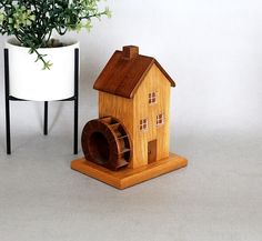 a small wooden house next to a potted plant