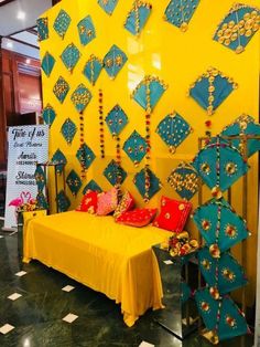 a yellow bed sitting in front of a wall with blue and red decorations on it