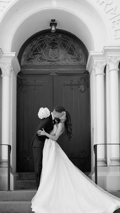 a bride and groom kissing in front of an ornate doorway