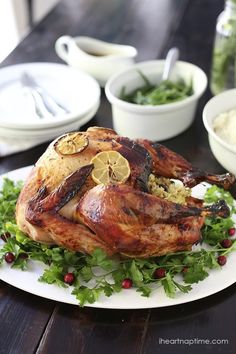 a whole chicken on a plate with garnishes and other dishes around it