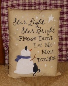 a snowman pillow sitting on top of a couch next to a plaid chair with the words starlight, star bright please don't let me met tonight