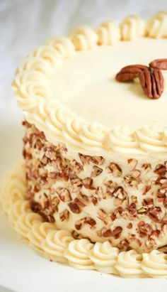 a cake with white frosting and pecans on top