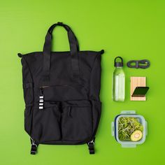 a lunch bag, water bottle and other items laid out on a green surface