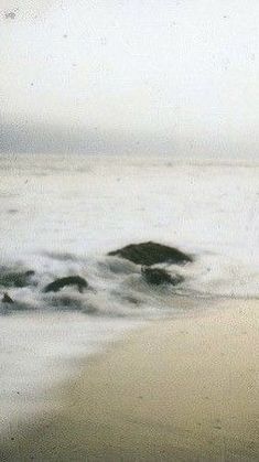 a blurry photo of the ocean with rocks in the water