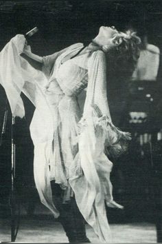 an old black and white photo of a woman with a microphone in her hand, dancing