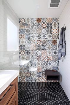 a bathroom with black and white tiles on the wall