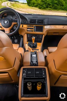 the interior of a car with brown leather and wood trims, including an automatic steering wheel