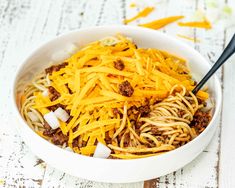 a white bowl filled with spaghetti and cheese