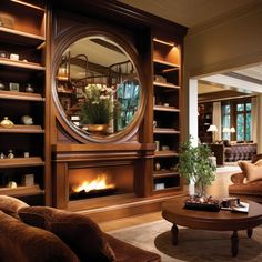 a living room filled with furniture and a fire place in front of a large mirror