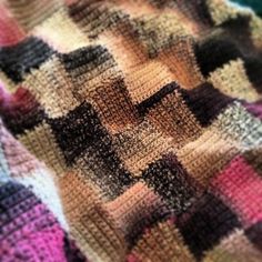 a close up view of a knitted blanket that has squares and dots on it