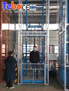 two men in black coats and masks are standing near a large metal caged area