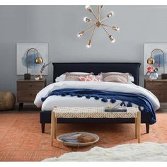 a bedroom with a bed, nightstands and pictures on the wall above it that is decorated in blue and gold