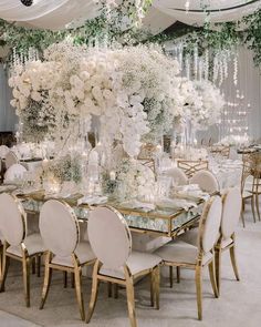 an elegant wedding reception with white flowers and greenery