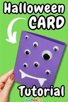 someone is holding up a purple card with googly eyes and a smile on it