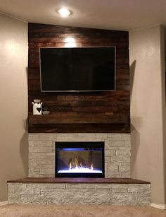 a fireplace with a flat screen tv mounted above it and a fire place in the corner