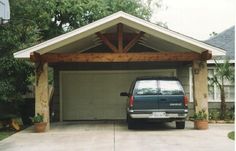 a car parked in front of a house with a carport attached to the roof