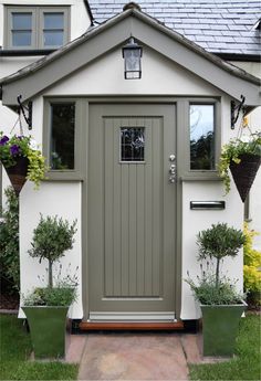 the front door of a house with potted plants