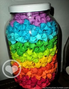 a large jar filled with lots of different colored paper bow ties on top of it