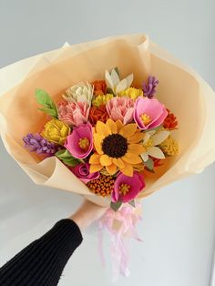 a person holding a bouquet of flowers in their hand