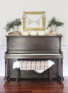 an old piano is decorated with greenery and white pumpkins for fall decorating