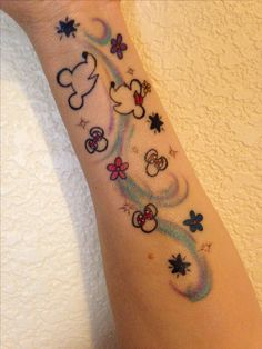 a woman's arm with mickey mouse tattoos on it