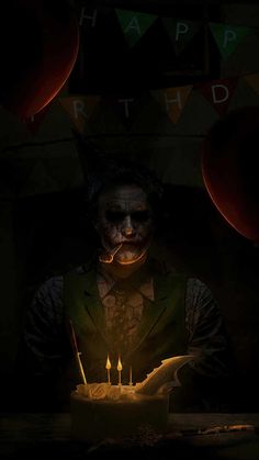 a creepy clown holding a lit candle in front of a cake with candles on it