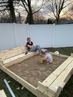 two children are playing in the sandbox