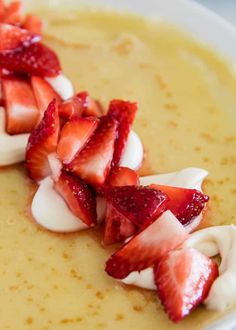 some strawberries on top of cream in a bowl