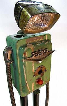 an old fashioned green machine with a light on it's head and nozzles