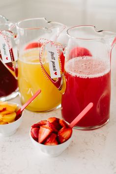 pitchers filled with different types of fruit on a table