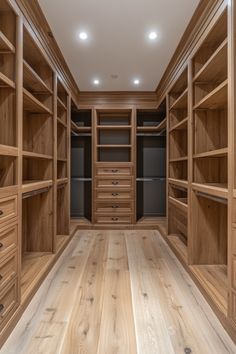 an empty walk - in closet with wooden shelves and drawers on each side, lighting from the ceiling