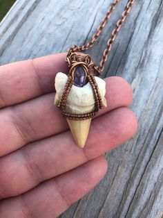 Otodus Fossil Shark Tooth Wire Wrapped Pendant with Natural Amethyst in Antiqued Copper with Chain A 65 million year old fossil shark tooth from the extinct shark Otodus is wire wrapped in antiqued copper with a beautiful natural purple amethyst. Shark tooth pendants and necklaces are said to offer protection from evil. And keep anyone who swims in the water safe Comes with an 18inch antiqued copper chain If you have any questions please feel free to message me If outside of the US please contac Wire Wrapped Bones, Purple Amethyst Jewelry With Soldered Details, Adjustable Electroformed Purple Jewelry, Adjustable Purple Electroformed Jewelry, Soldered Purple Pendant Jewelry, Purple Soldered Pendant Jewelry, Handmade Arrowhead Jewelry Gift, Wire Wrap Shark Tooth, Shark Tooth Jewelry