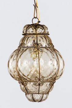 an old fashioned glass light hanging from a ceiling