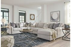 a living room filled with furniture and lots of windows