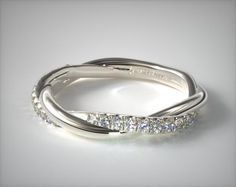 a white gold wedding ring with three rows of diamonds on the side and an open band