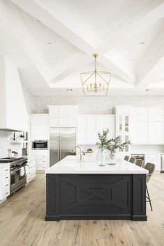 a large kitchen with white cabinets and an island