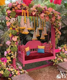 a pink and yellow swing bed with flowers around it