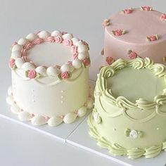 there are three cakes that are on the table together, one is pink and one is green