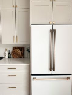 a white refrigerator freezer sitting inside of a kitchen next to wooden counter tops and cabinets