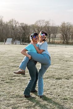 two women are in the middle of a grassy field