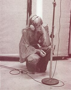 a woman sitting in front of a microphone with headphones on