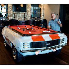 a man standing next to a pool table