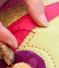 a close up of a person's hands working on a piece of fabric