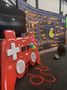 a red video game controller sitting on top of a black carpet