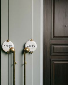 two white and gold door handles with numbers on them