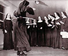 an old black and white photo of women dressed in nun costumes, with one holding a hula hoop