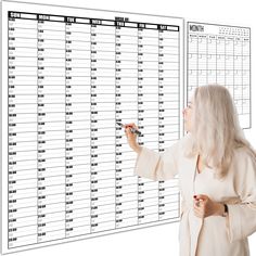 a woman writing on a large white board